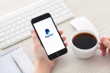 Alushta - 25 Ekim 2014: Ekranda PayPal servisi olan iPhone 6 Space Gray 'i tutan kız. iPhone 6 Apple Inc. tarafından oluşturuldu ve geliştirildi.