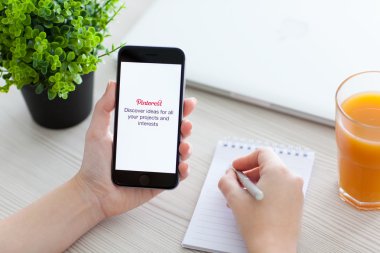 Alushta - 24 Ekim 2014: Ekranda sosyal internet servisi Pinterest ile iPhone 6 Space Gray 'i tutan kız. iPhone 6 Apple Inc. tarafından oluşturuldu ve geliştirildi.