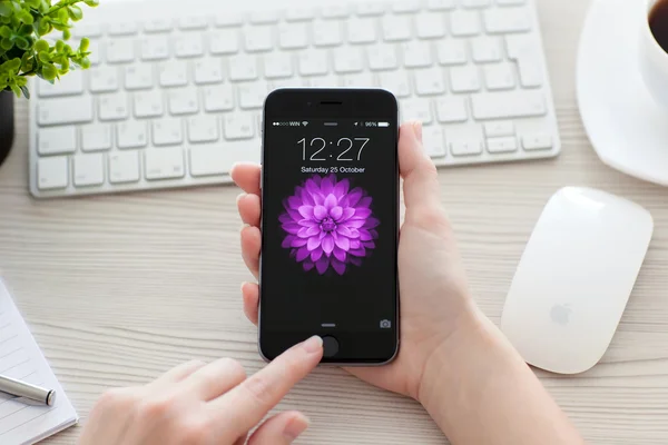 Alushta 2014年10月25日 女孩在桌上打开她的Iphone Space Gray手机 Iphone 6是由Apple Inc创建和开发的 — 图库照片