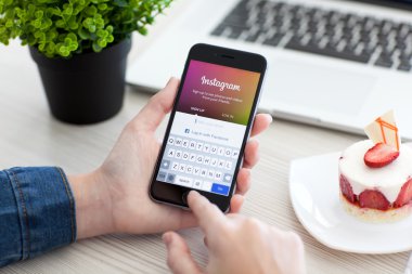 Alushta - 28 Ekim 2014: Ekranda sosyal ağ servisi Instagram ile iPhone 6 Space Gray 'i tutan kadın. iPhone 6 Apple Inc. tarafından oluşturuldu ve geliştirildi