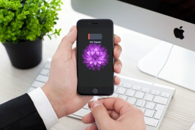 Alushta - 3 Kasım 2014: Ekranda pil simgesi olan iPhone 6 Space Gray 'i tutan adam. iPhone 6 Apple Inc. tarafından oluşturuldu ve geliştirildi.