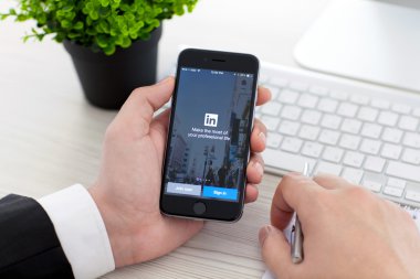 Alushta - 3 Kasım 2014: Sosyal ağ servisi LinkedIn ile birlikte iPhone 6 Space Gray 'i elinde tutan iş adamı. iPhone 6 Apple Inc. tarafından oluşturuldu ve geliştirildi.