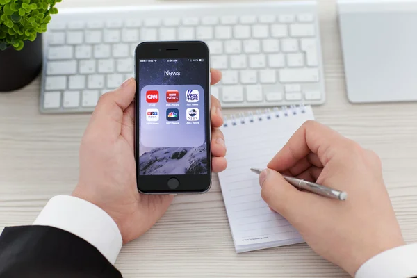Alushta 11月3 2014 ビジネスマンは 画面上の人気のあるニュースアプリケーションとIphone 6スペースグレーを保持 Iphone 6はApple Inc によって作成および開発されました — ストック写真