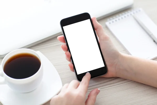 Mujeres manos sosteniendo el teléfono con pantalla aislada sobre el escritorio —  Fotos de Stock