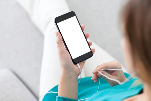 Woman holding a phone with isolated screen and headphones — Stock Photo, Image