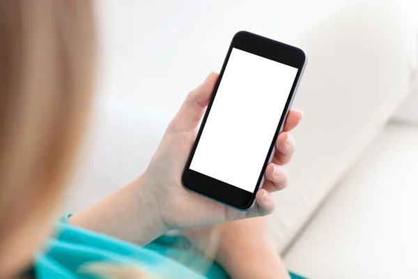 Frau hält ein Telefon mit isoliertem Bildschirm auf einem Sofa — Stockfoto