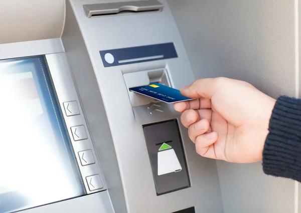 Человек кладет кредитку в банкомат — стоковое фото