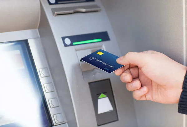 Man puts credit card into ATM — Stock Photo, Image