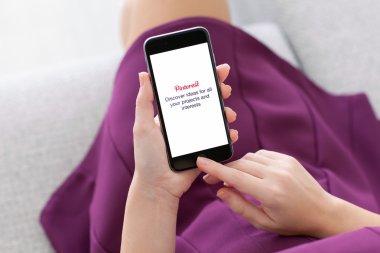 Alushta - 22 Kasım 2014: Ekranda sosyal internet servisi Pinterest ile iPhone 6 Space Gray 'i tutan kadın. iPhone 6 Apple Inc. tarafından oluşturuldu ve geliştirildi.