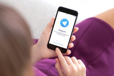 Alushta - 22 Kasım 2014: Ekranda sosyal ağ servisi Telegram ile iPhone 6 Space Gray 'i tutan kadın. iPhone 6 Apple Inc. tarafından oluşturuldu ve geliştirildi.