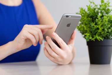 Alushta - 3 Aralık 2014: Elinde yeni bir iPhone 6 Space Gray tutan kadın. iPhone 6 Apple Inc. tarafından oluşturuldu ve geliştirildi.