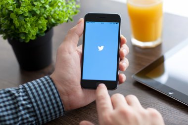 Alushta - 21 Kasım 2014: Ekranda sosyal ağ hizmetleri Twitter ile iPhone 6 Space Gray 'i tutan adam. iPhone 6 Apple Inc. tarafından oluşturuldu ve geliştirildi.