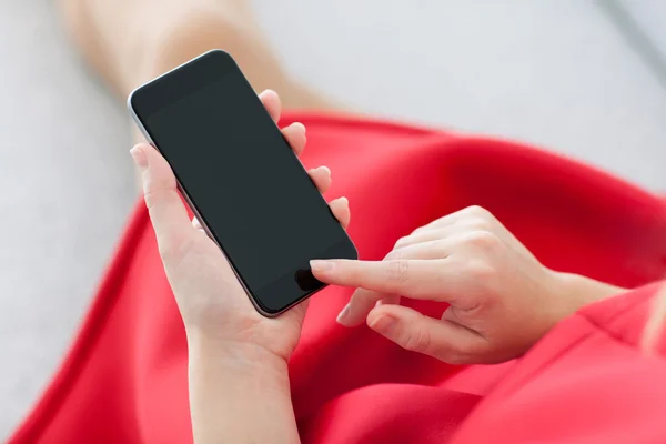 Dziewczynka w czerwonej sukience trzymając telefon czarny — Zdjęcie stockowe