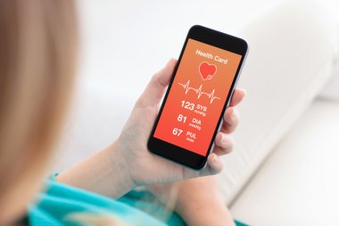 bir telefon kartı sağlık izleme uygulaması ile tutan kadın