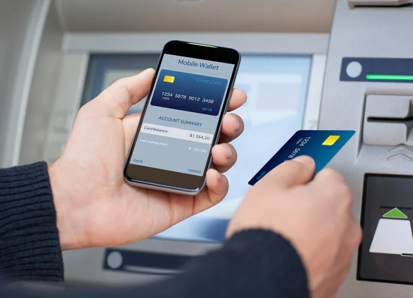 Ember tartja a telefon mobil pénztárca az ATM — Stock Fotó