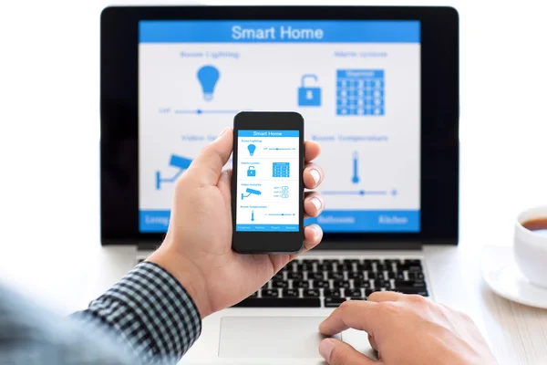 Mann hält Handy mit Programm Smart Home auf dem Bildschirm — Stockfoto