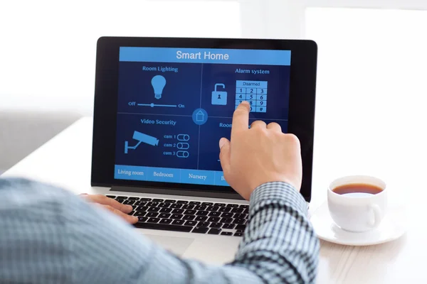 Mann sitzt am Laptop mit dem Programm Smart Home — Stockfoto