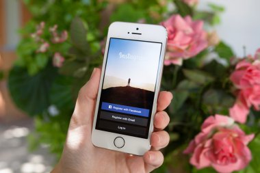 Alushta - 30 Eylül 2014: Ekranda sosyal ağ servisi Instagram 'lı iPhone 5 S tutan kadın. iPhone Apple tarafından oluşturuldu ve geliştirildi..