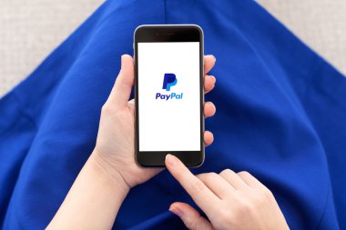 Alushta - 3 Aralık 2014: Ekranda PayPal servisi olan iPhone 6 Space Gray 'i tutan kadın. iPhone 6 Apple Inc. tarafından oluşturuldu ve geliştirildi.