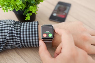 Alushta - 11 Ağustos 2015: Apple Watch ile adam eli ve ekranda telefon görüşmesi. Apple Watch Apple tarafından yaratıldı ve geliştirildi..