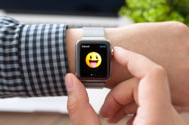 Alushta - 11 Ağustos 2015: Apple Watch ile adam eli ve ekranda gülümseme. Apple Watch Apple tarafından yaratıldı ve geliştirildi..