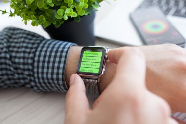 Alushta - 14 Ağustos 2015: Apple Watch ile insan eli ve ekranda uygulama çalışması. Apple Watch Apple tarafından yaratıldı ve geliştirildi..