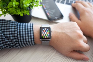 Alushta - 14 Ağustos 2015: Apple Watch ile insan eli ve ekranda uygulama simgesi. Apple Watch Apple tarafından yaratıldı ve geliştirildi..