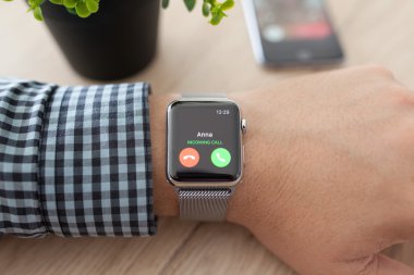 Alushta - 11 Ağustos 2015: Apple Watch ile adam eli ve ekranda telefon görüşmesi. Apple Watch Apple tarafından yaratıldı ve geliştirildi..