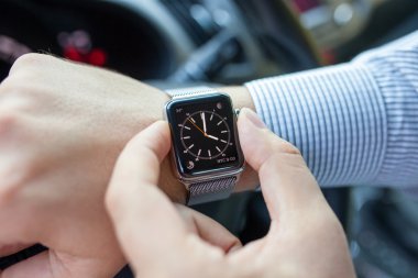 Alushta - 3 Eylül 2015: Elma saati ve saati ekranda olan adam elini arabaya koydu. Apple Watch Apple tarafından yaratıldı ve geliştirildi..