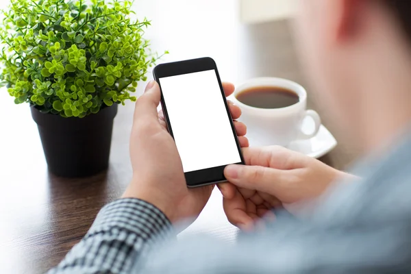 Man håller en telefon med isolerade skärm i ett café — Stockfoto
