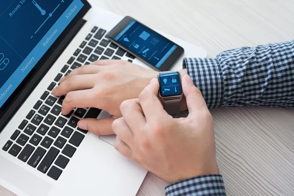 Az ember kezét a watch-Szúró otthoni számítógép és a telefon — Stock Fotó