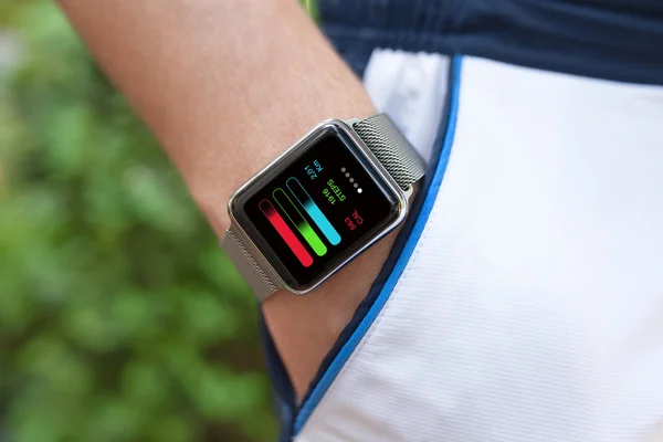 Mão de atleta com relógio e aplicativo de treinamento na tela — Fotografia de Stock