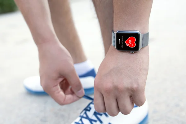 Mano del atleta con el reloj y la salud de la aplicación en la pantalla — Foto de Stock