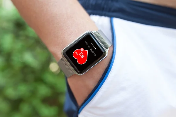 Mano del atleta con el reloj y la salud de la aplicación en la pantalla —  Fotos de Stock