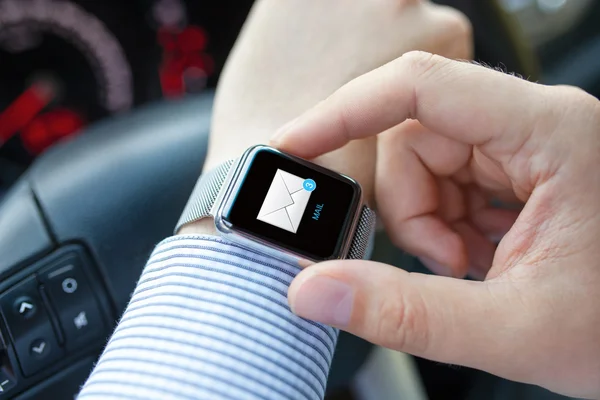 Man hand in car with watch and e-mail on screen — Stock Photo, Image