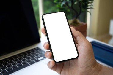 Ofis masasının üstündeki bilgisayarın arka planında tek başına duran erkek el bilgisayarı.