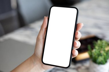 Ofis kafeteryasında tek kişilik ekranı olan bir kadın telefonu elinde tutuyor.