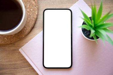 Ofisteki masanın üzerinde izole ekran arkaplan pembe not defteri olan telefon