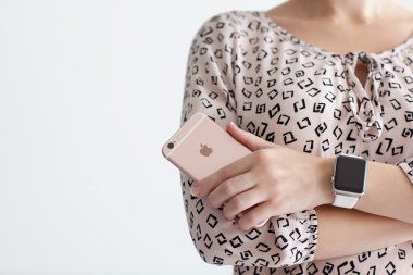 Alushta - 22 Ekim 2015: Ellerinde Apple Watch olan kadın iPhone 6 S Rose Gold 'u tutuyor. iPhone 6S ve Watch Apple tarafından oluşturuldu ve geliştirildi..