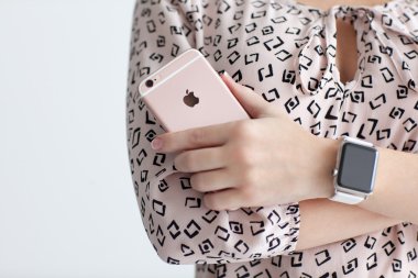 Alushta - 22 Ekim 2015: Ellerinde Apple Watch olan kadın iPhone 6 S Rose Gold 'u tutuyor. iPhone 6S ve Watch Apple tarafından oluşturuldu ve geliştirildi..