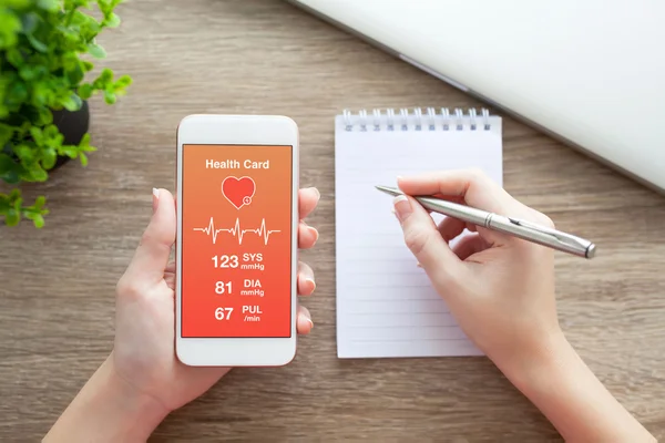 Female hands holding phone with health card on the screen — Stock Photo, Image