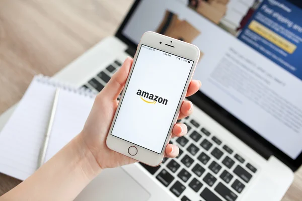 Γυναίκα που κρατά iphone 6s ροζ επιχρυσωμένο με Amazon στην οθόνη — Φωτογραφία Αρχείου