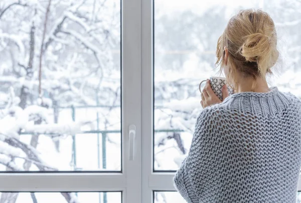 Egy nő néz ki az ablakon a hófödte szabadban. Jogdíjmentes Stock Képek
