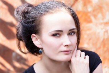 Dudağına piercing takmış güzel bir genç kadının portresi.