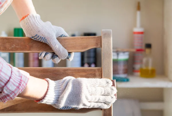 Close-up of a womans hands restoring an old chair Stockfoto