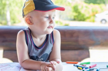 Balmumu boyalı bir bebek düşünceli bir şekilde uzaklaşıyor.