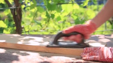 Bir kadın iş eldiveni verir zımpara kağıdıyla bir tahta zımparalar