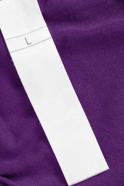 Bekleidungsetikett Größe Auf Lila Gestricktem Hintergrund Nahaufnahme — Stockfoto