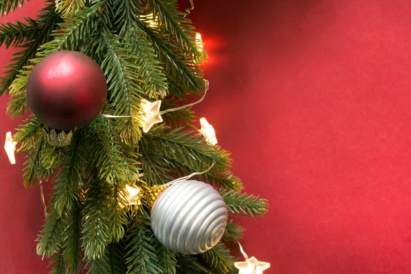 Kırmızı Arka Planda Işıklar Toplarla Süslenmiş Noel Ağacı Dalı — Stok fotoğraf