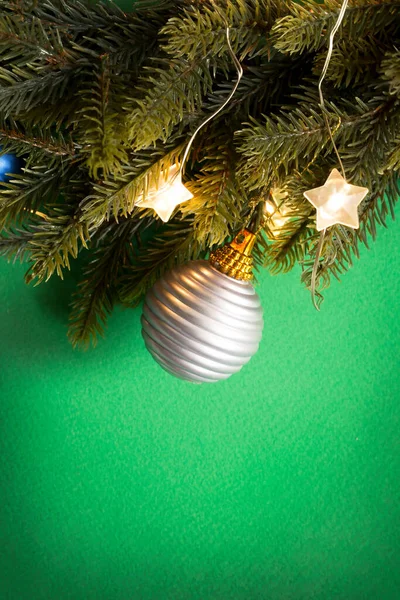 緑の背景にシルバーボールとライトが閉じクリスマスツリーの枝 — ストック写真